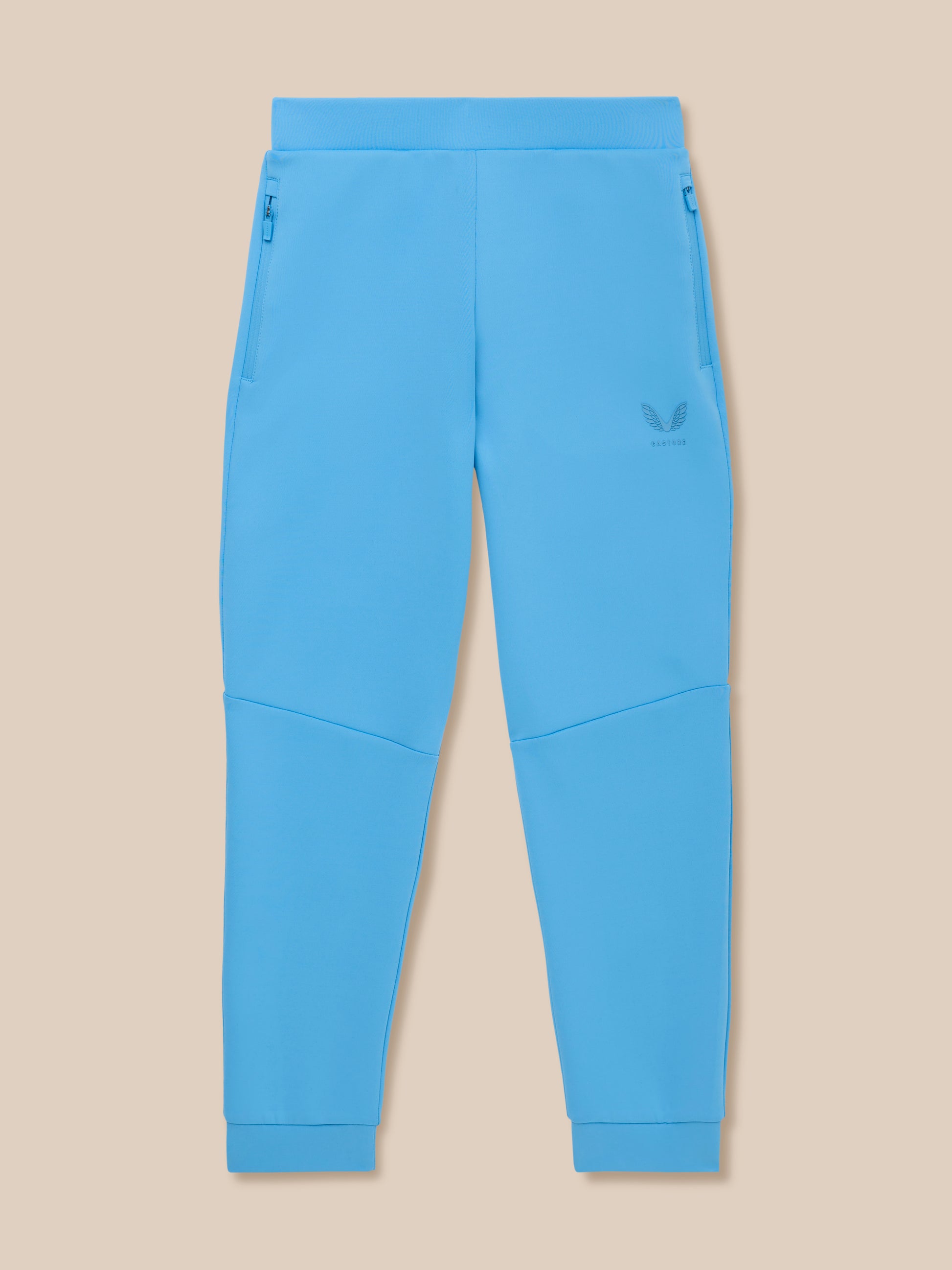 Bright blue junior Flex scuba trousers with zip pockets and Castore logo on the left leg.