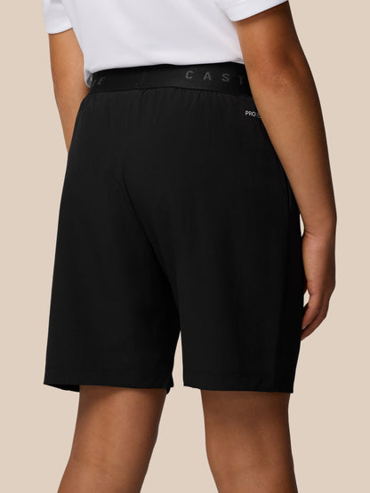 Close up of the waistband area on black Junior’s Adapt Woven Shorts showing Castore branding and ProTek detailing.