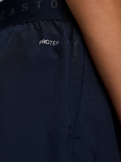 Close-up of navy Junior’s Adapt Woven Shorts fabric with water droplets and ProTek branding