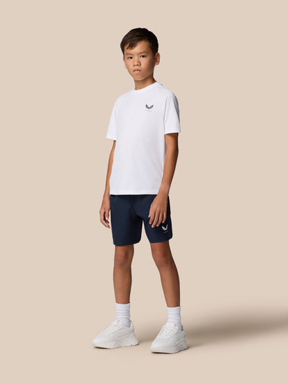 Side view of a boy in a white Junior's Adapt Training T-Shirt with Castore logo on the chest and navy shorts