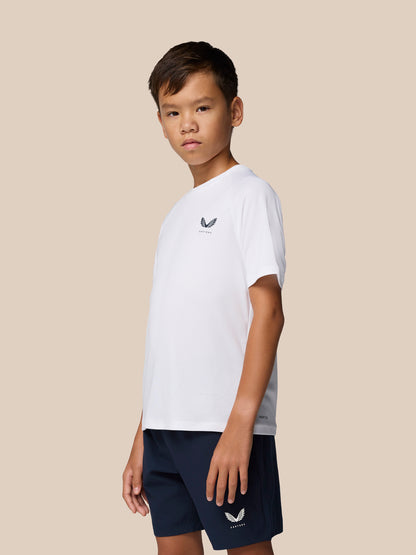 Front three-quarter view of a boy wearing the white Adapt Training T-Shirt with Castore logo on the chest and navy shorts