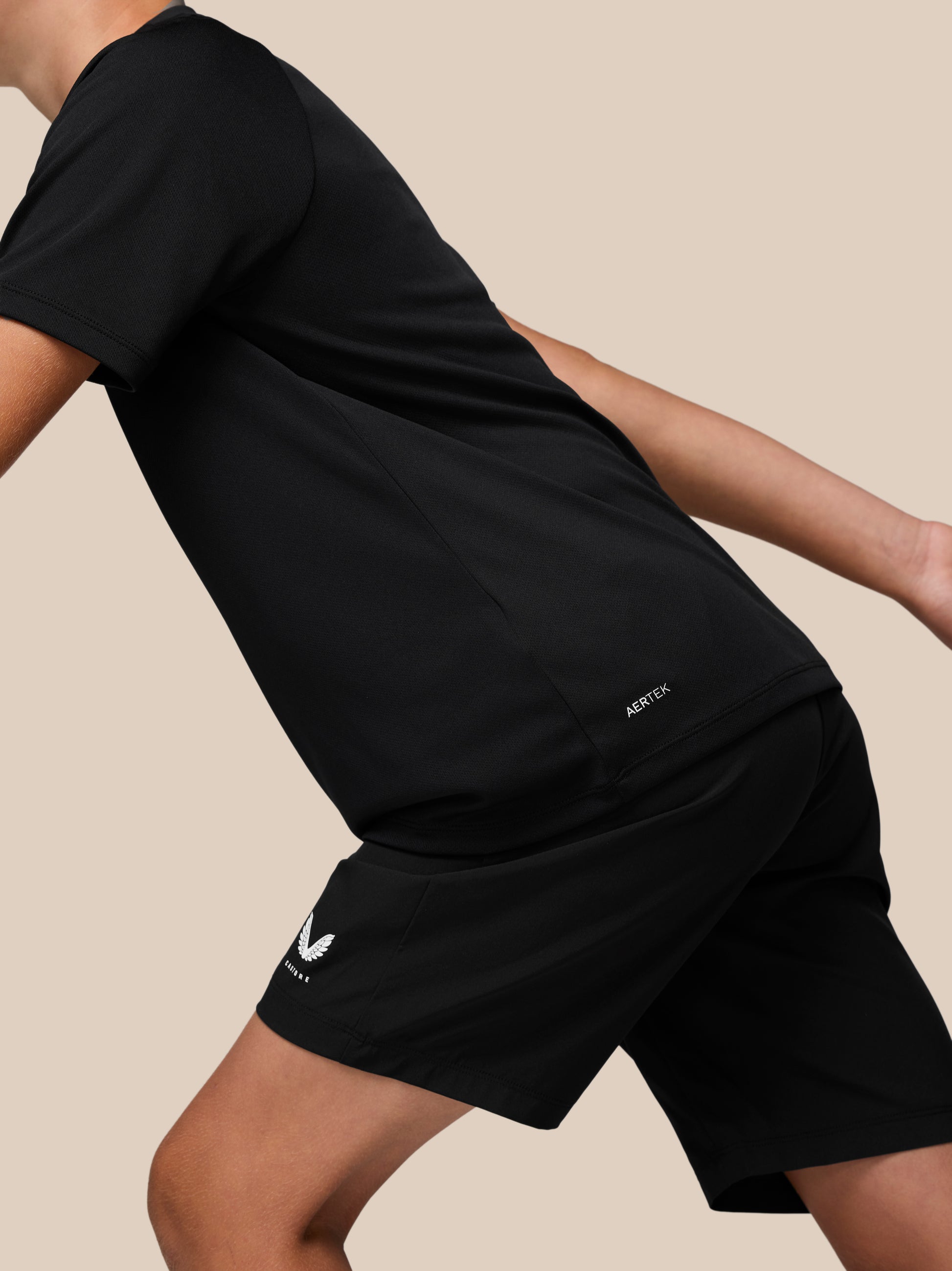 Detail of the black Junior Adapt Short Sleeve T Shirt showing AerTek branding at the lower hem