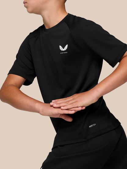 Close up of black Junior’s Adapt Short Sleeve T Shirt with white Castore logo on the left chest