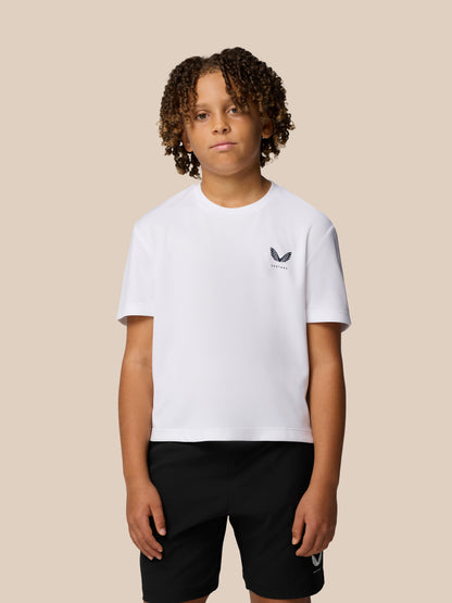 Young model wearing a white Junior Adapt Short Sleeve T Shirt with reflective Castore logo on the chest