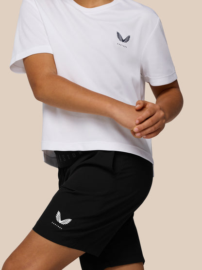 Side view of a person wearing a white Castore Adapt short sleeve T shirt with left chest logo and black shorts