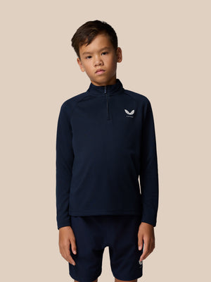 Front view of a young boy wearing navy Adapt Lightweight Quarter Zip with raglan sleeves and a center front zip with a left chest logo