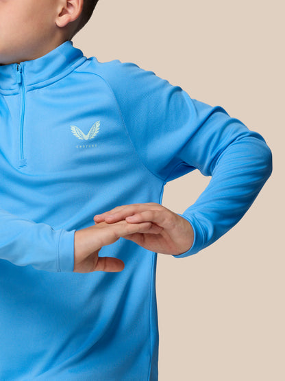 Close-up of a junior light blue quarter zip training top with a white wing logo on the chest
