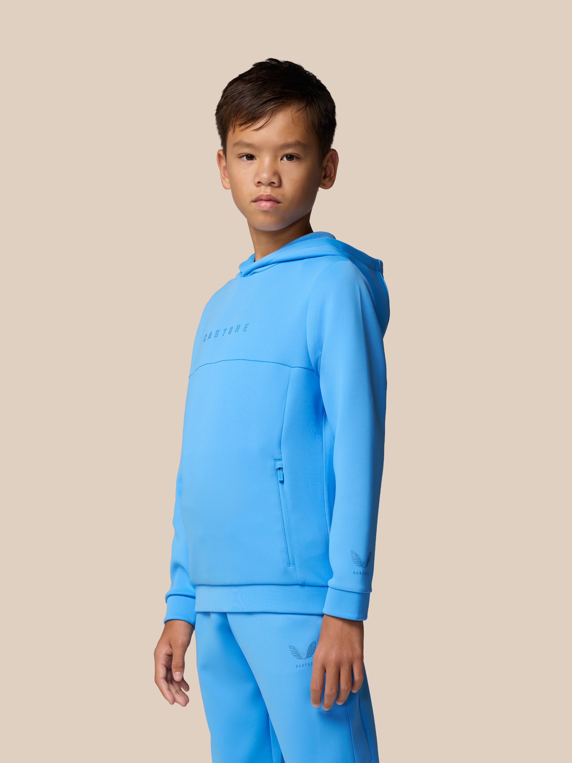 Junior’s Flex Scuba hoodie in blue worn by a young boy in a studio with a beige background