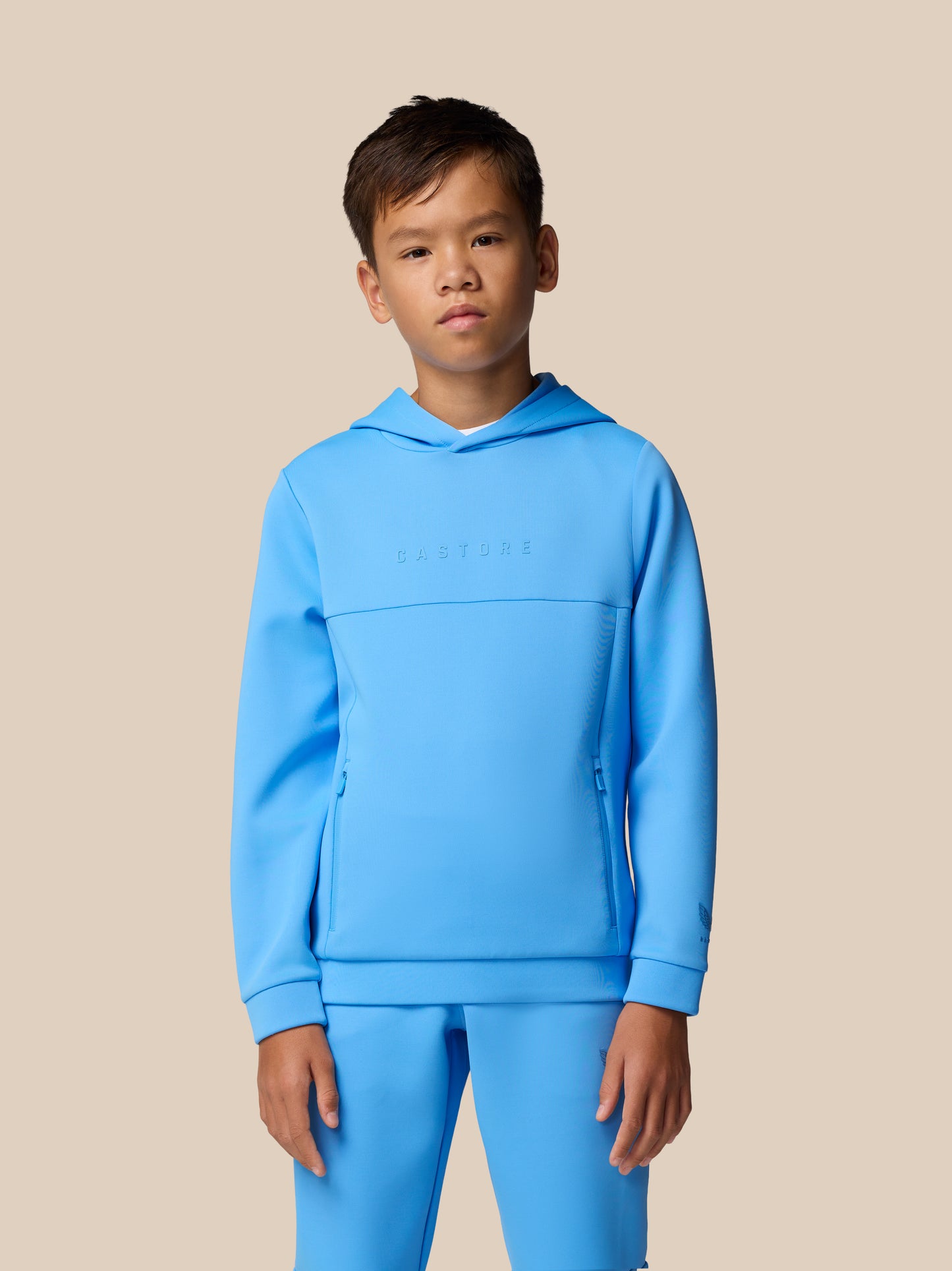 Young boy models Junior’s Flex Scuba Long Sleeve Hoodie in Cool Blue featuring a hood and subtle chest branding.
