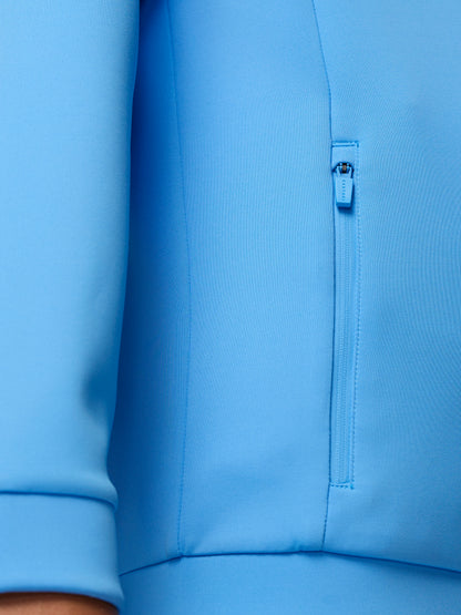 Close up of bright blue scuba fabric showing a vertical zip and seam detail on a hoodie