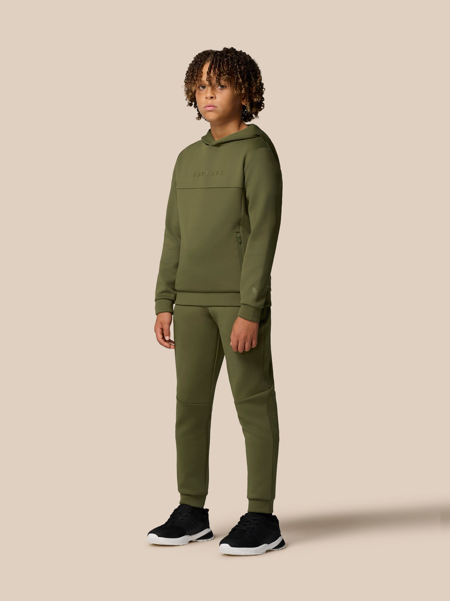 Front view of a young model in an olive green hoodie and matching joggers with hood up.