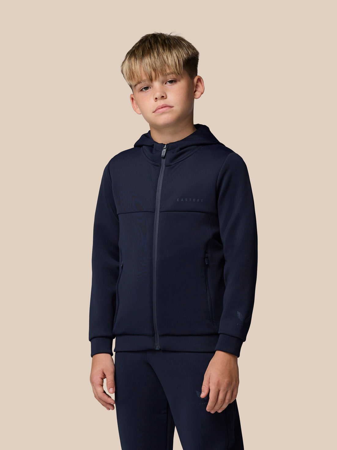 Boy wearing navy junior Flex Scuba full zip hooded jacket with zip pockets.