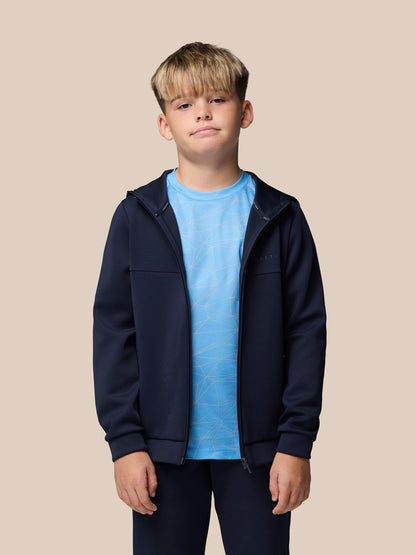 Boy modeling navy Flex scuba jacket unzipped with blue geometric tee visible, navy joggers, white sneakers