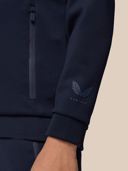 Close-up of navy jacket sleeve with Castore emblem near the cuff
