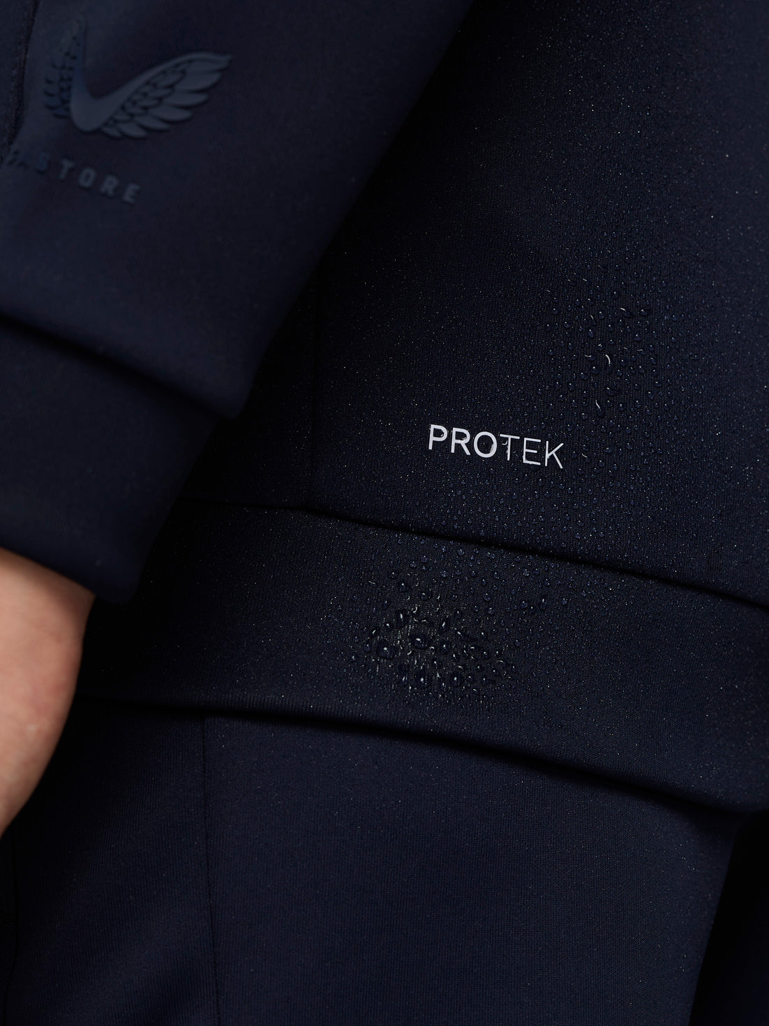 Close up of navy jacket fabric with ProTek logo and sleeve branding