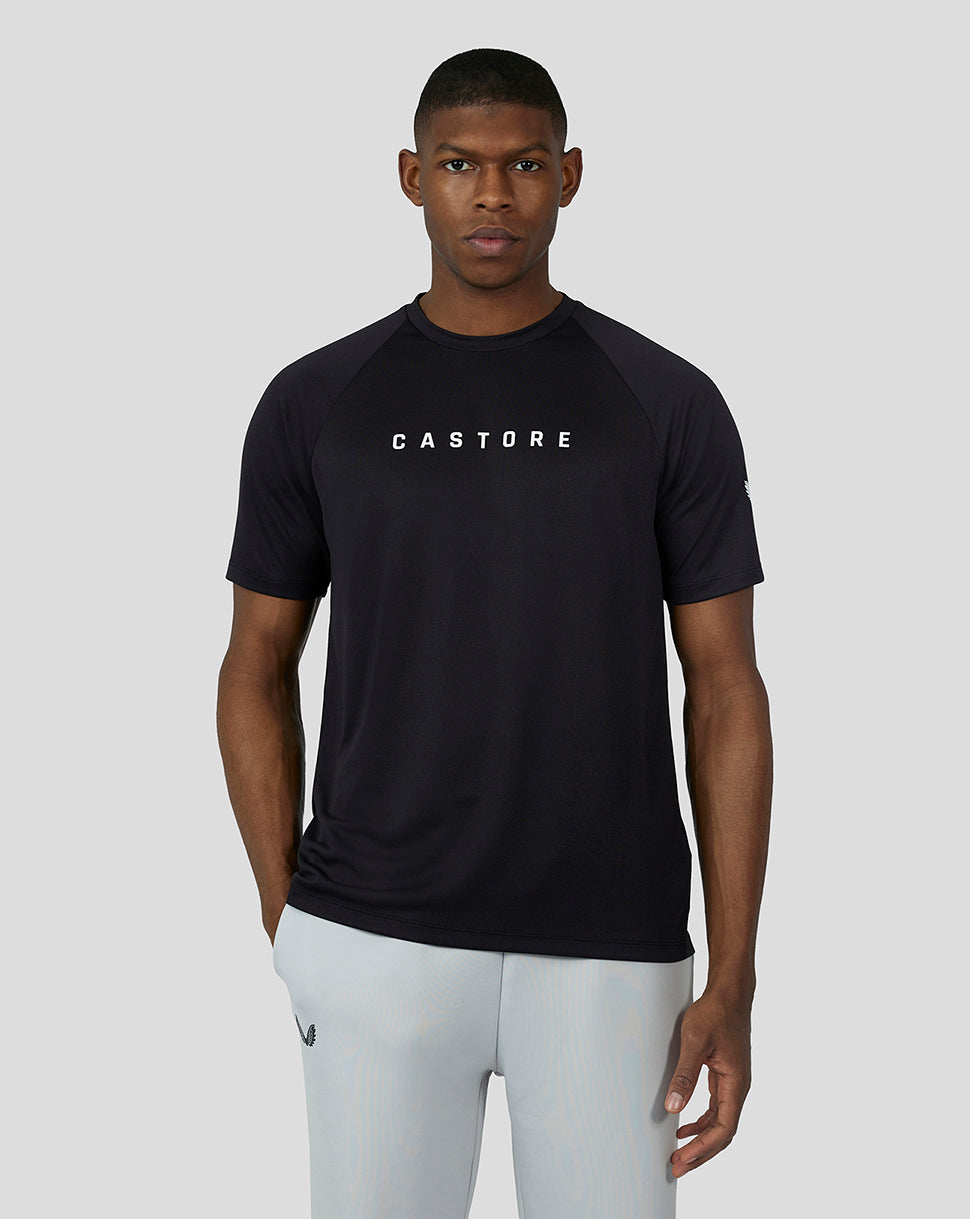 Male model in black short sleeve raglan tee with white Castore branding on chest and raglan sleeves