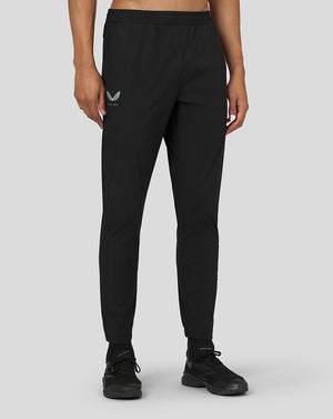 Front view of black active woven joggers with elastic drawcord waistband and Castore logo on the left thigh