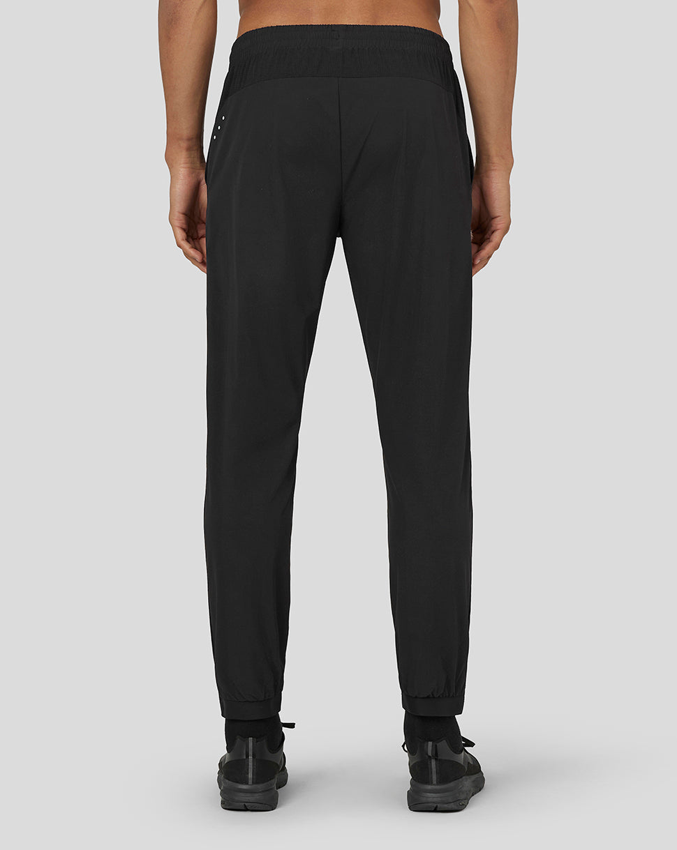 Back view of black active woven joggers showing elastic waistband and a subtle reflective detail along the back