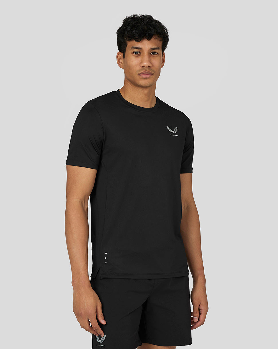Front view of a man in black Castore performance short sleeve tee with left chest logo and reflective hem details