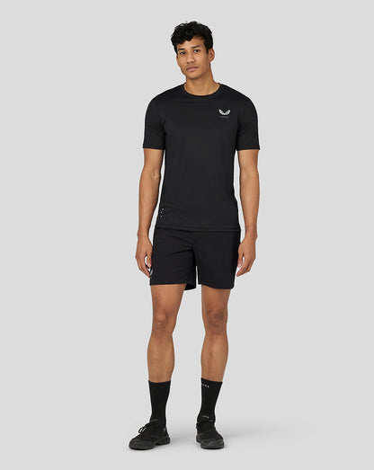 Full-body shot of male model in black Castore performance T shirt and matching black shorts