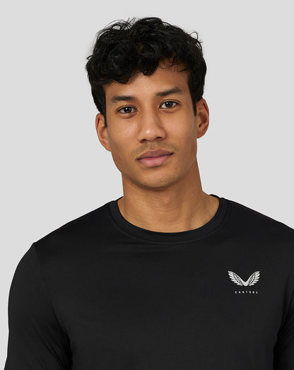 Three quarter front view of a man wearing black Castore performance tee with left chest logo