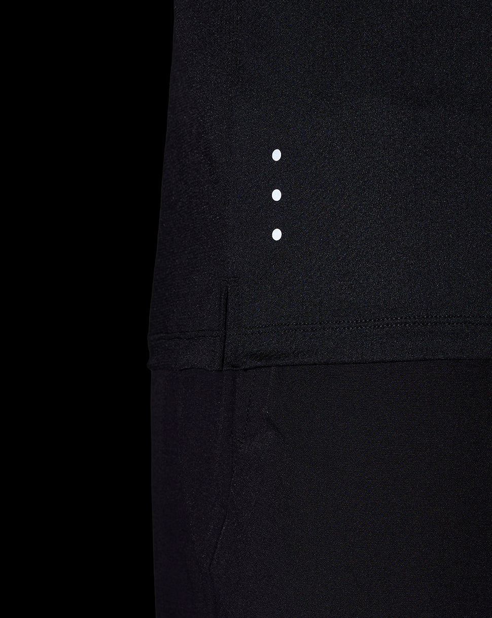 Close-up of black performance T shirt fabric with three white reflective dots along the side seam