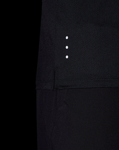 Close-up of black performance T shirt fabric with three white reflective dots along the side seam