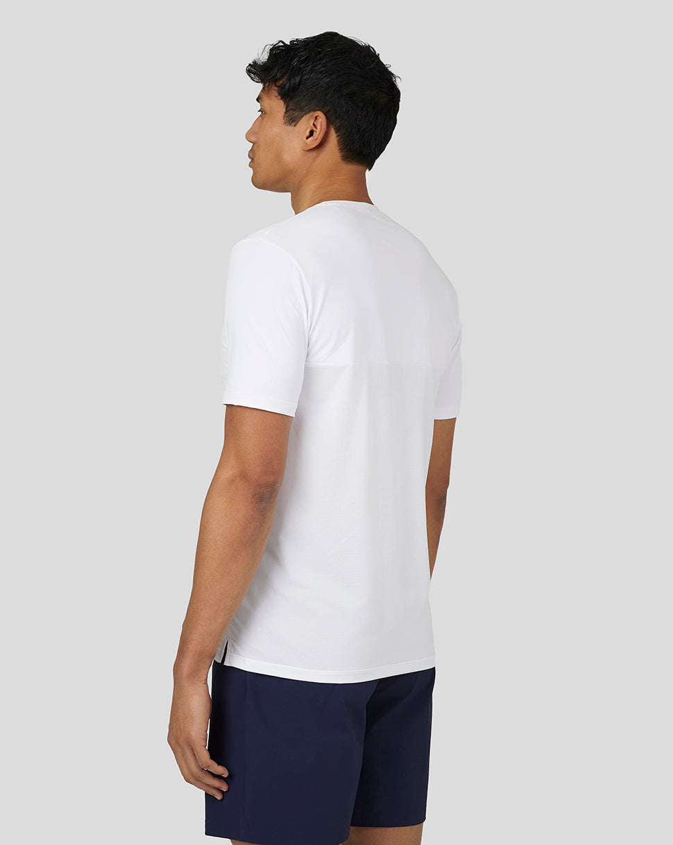 Back view of a man in a white performance short sleeve T shirt with a mesh back panel
