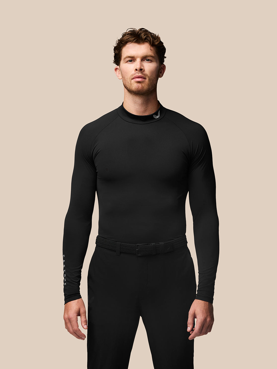 Male golfer wearing a black long sleeve golf baselayer with stand collar