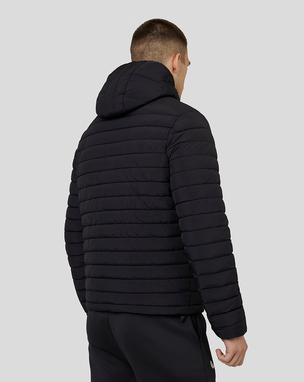 Back view of a man in a black hooded puffer jacket with quilted panels and a hood