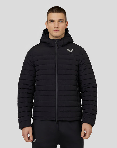 Front view of a man wearing a black hooded puffer jacket with Castore branding on the left chest
