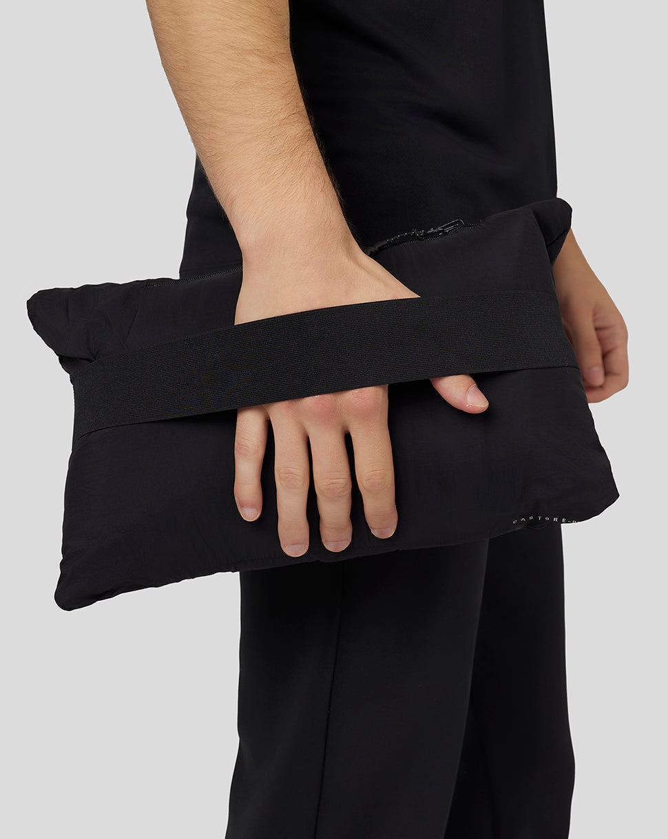 Model holding the packable hooded jacket in its compact carry pouch