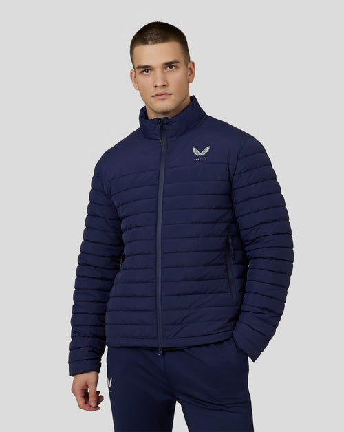 Man wearing navy travel lightweight puffer jacket with left chest logo