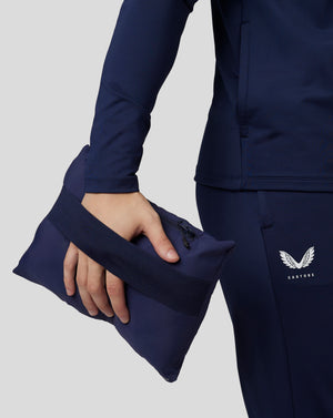 Navy Castore travel lightweight puffer jacket sleeve with a zipped side pocket and Castore logo.