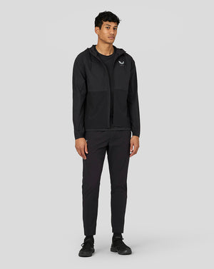 Male model wearing black Castore lightweight woven jacket with hood and full front zip