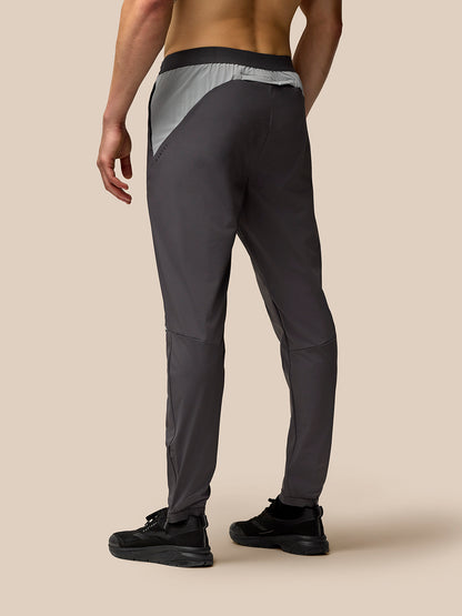 Back view of dark grey Flex joggers with a contrasting light grey waistband panel and curved seam details