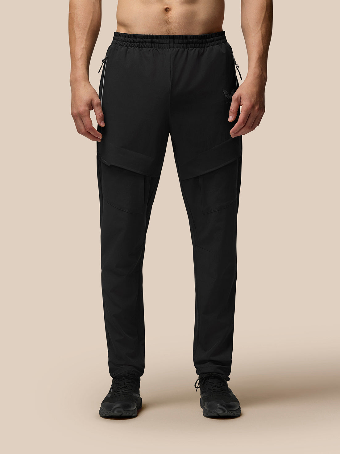 Lower-body shot of a man in black Flex Cargo Joggers with large thigh pockets and a tapered leg