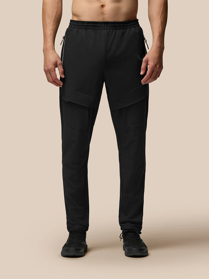 Lower-body shot of a man in black Flex Cargo Joggers with large thigh pockets and a tapered leg