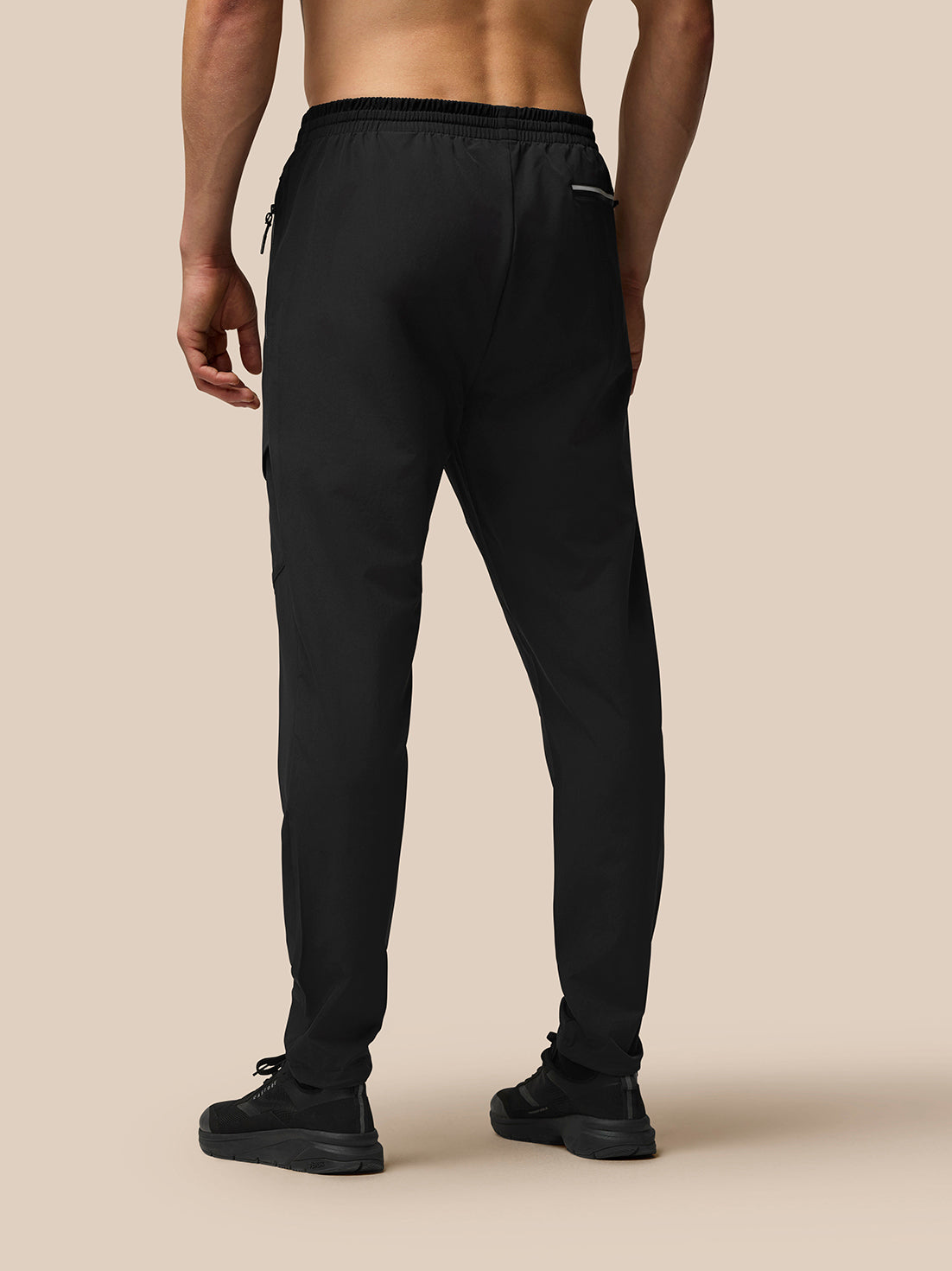 Back view of a model wearing black lightweight Flex Cargo Joggers with an elastic waistband and tapered cuffs.