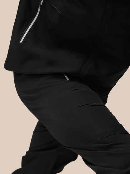 Close-up of black joggers showing a reflective zipper pocket and Castore branding on the thigh.