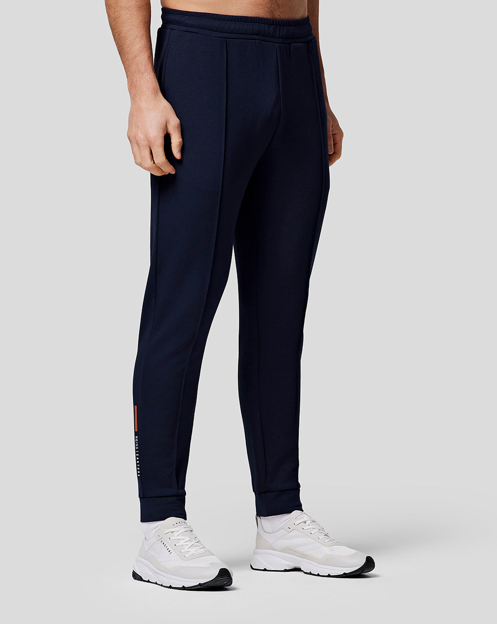 Man in midnight navy recovery joggers with tapered legs cuffed at the ankle and Castore branding on the lower right leg.