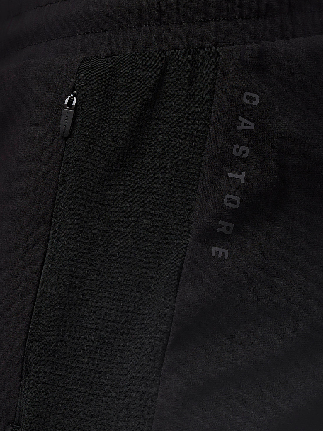 Close up of black Apex Training Shorts showing a side zip pocket and vertical Castore branding along the thigh