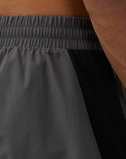 Close-up of the waistband and side seam on the gunmetal Apex Shorts featuring Protek branding