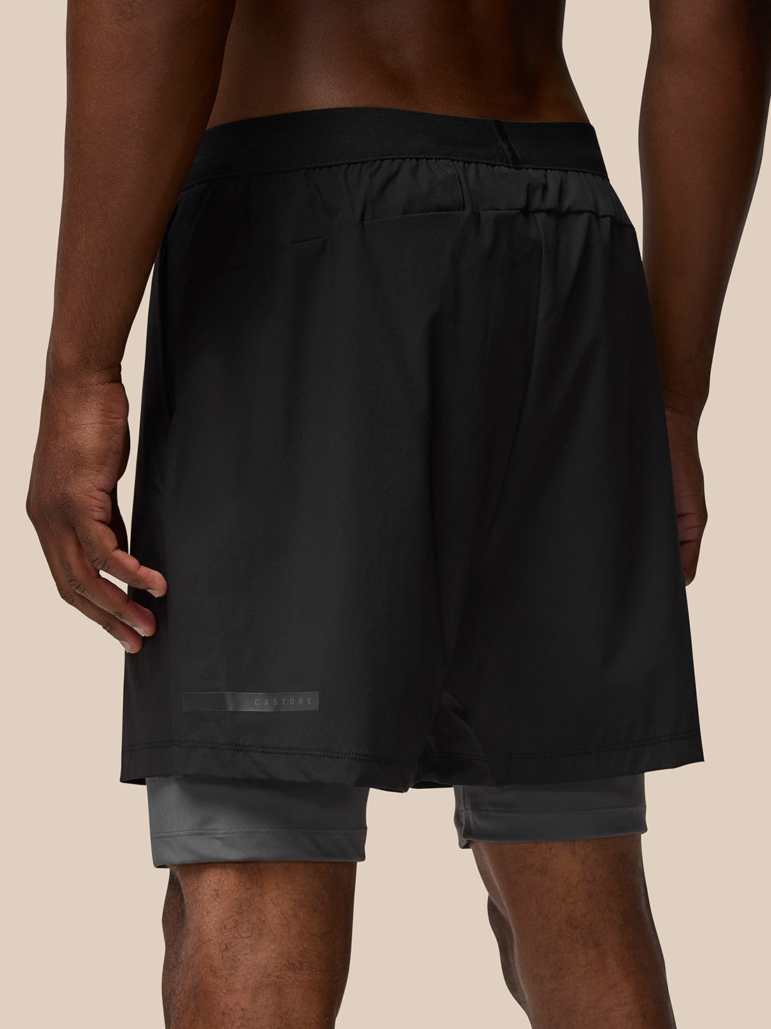Back view of black Flow Training Shorts with elastic waist and a Castore patch at the hem.