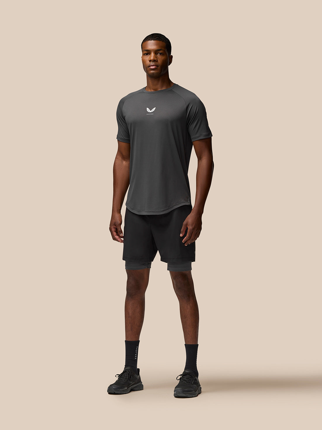 Male model wearing Flow Training Shorts in black with elastic waistband and side pockets; Castore branding on the thigh