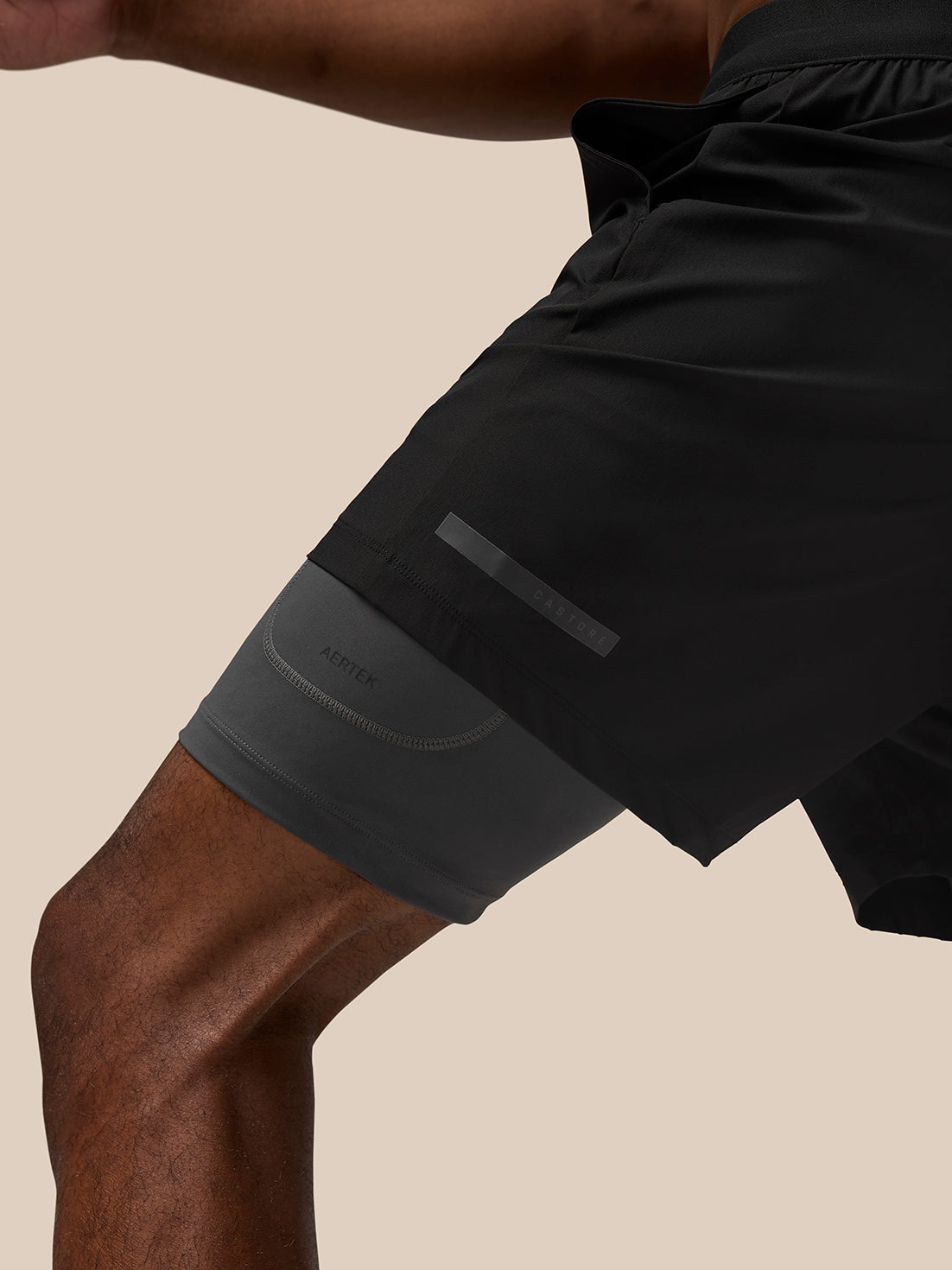 Black Flow Training Shorts with a gray underlayer visible, Aertek branding on the left thigh and a reflective Castore strip along the leg.