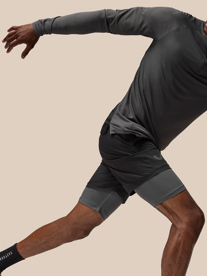 Profile view of black Flow Training Shorts over grey compression shorts with Castore logo on the thigh.