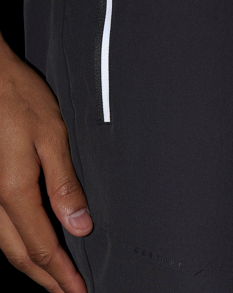 Side view of dark shorts with a white side stripe and Castore branding at the hem