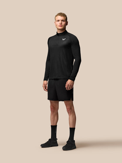 Full-body shot of a male model in black Adapt Training 7 inch shorts with a matching long sleeve top