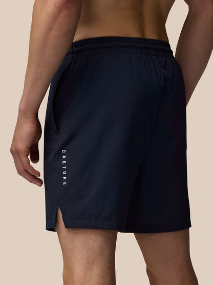 Back view of navy Adapt 7 inch shorts showing vertical Castore logo on the thigh and a side vent.